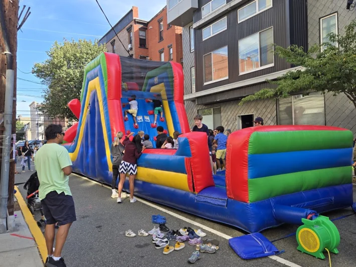 Kids climbing an inflatable obstacle course at the Connors Fall Festival