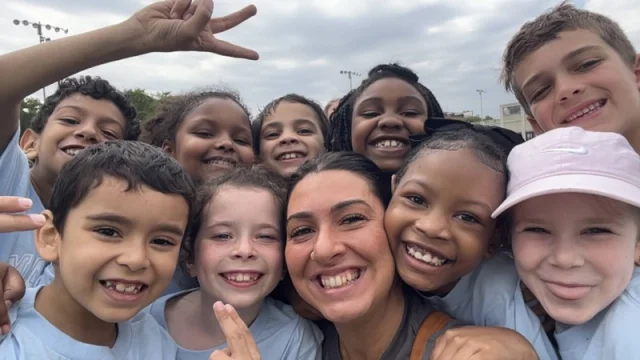 A Connors teacher and a crowd of students in light blue Field Day shirts crowding in for a selfie