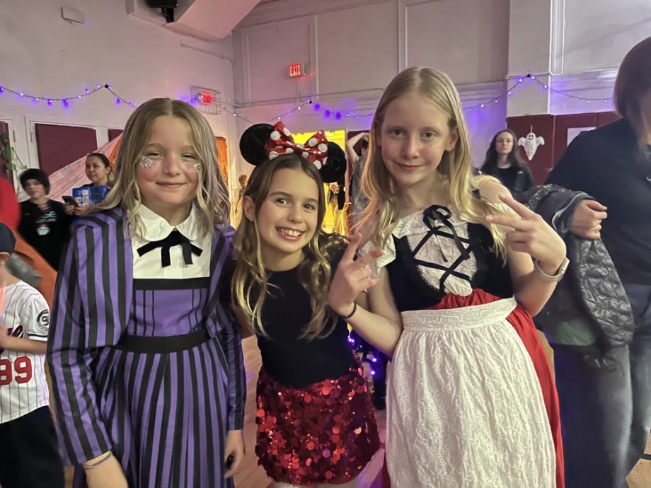 Girls in costumes smiling at the dance