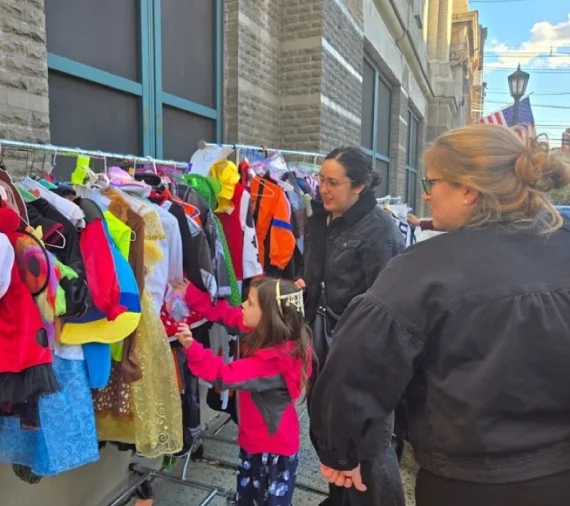 A child reaching for a costume at the free shop