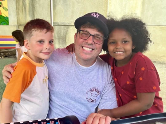 A Connors staff member with two students at a school event
