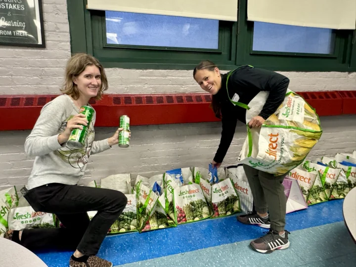 Two parents packing FreshDirect grocery bags for a Connors food drive