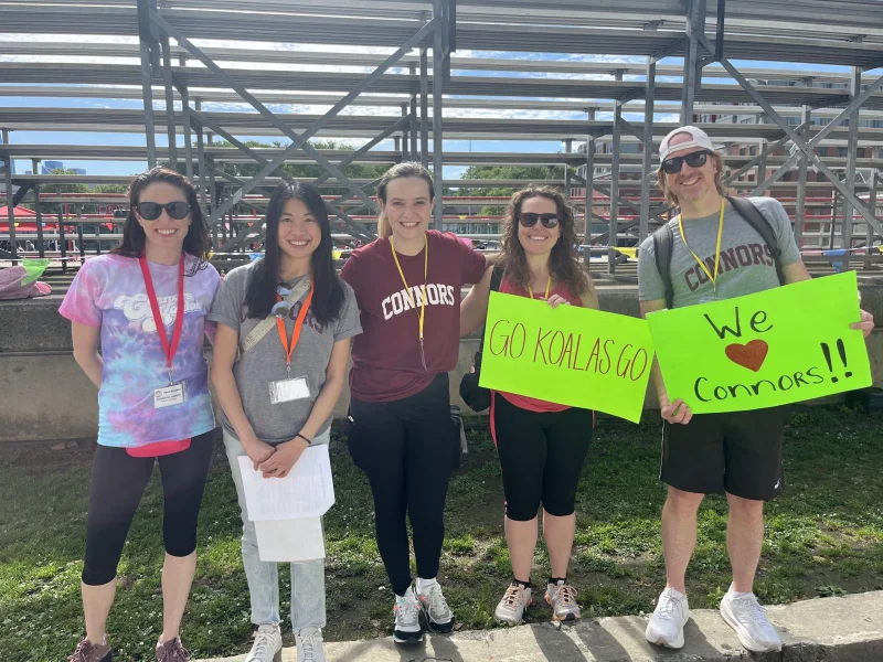 Connors PTO parent volunteers holding Go Koalas and We love Connors signs